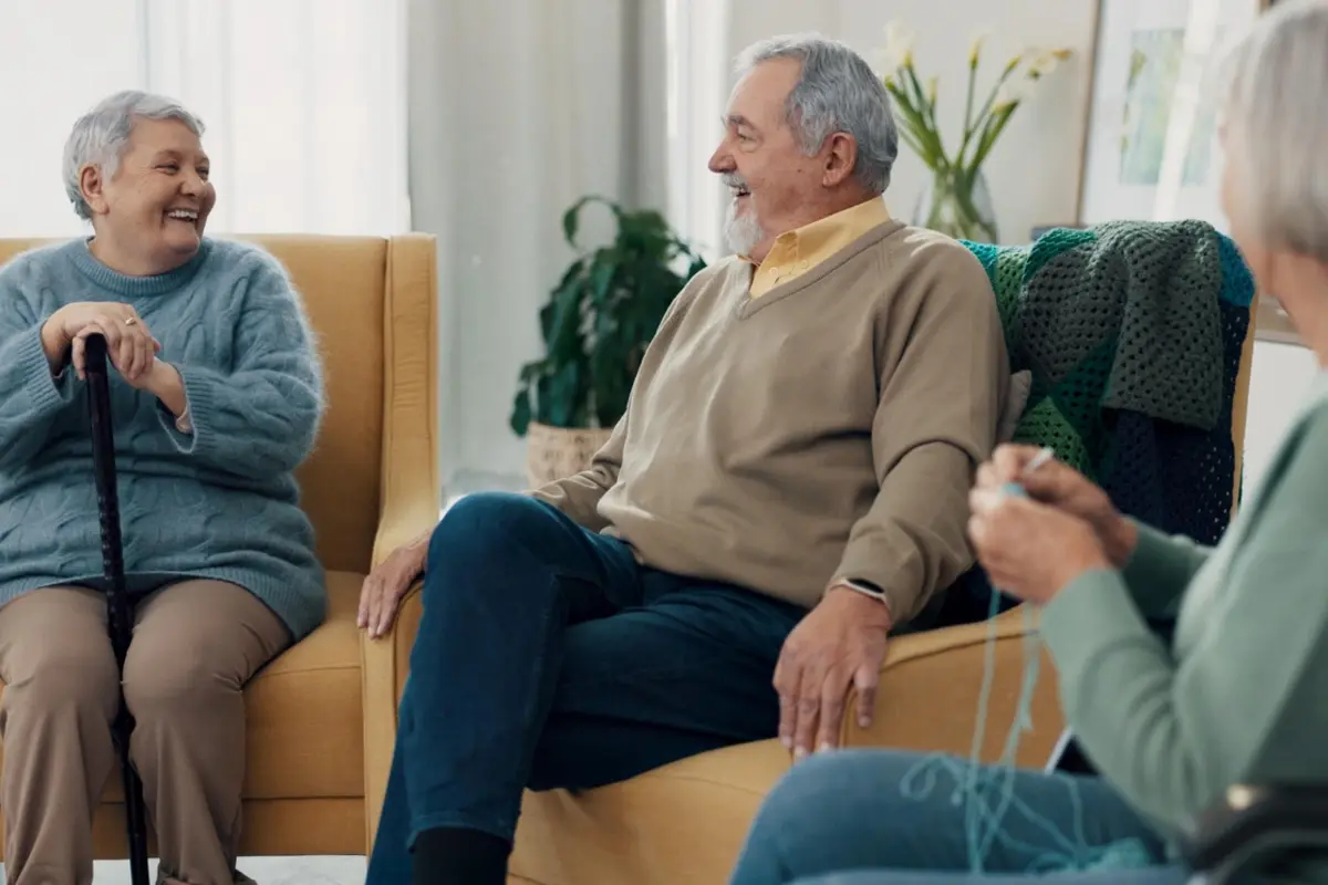 Older adults talking together in a living room, reflecting signs it’s time for assisted care and the social support families look for in Gresham, OR
